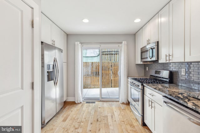 939 Sigel St, Philadelphia, PA 19148 - kitchen featuring appliances with stainless steel finishes, light wood-style flooring, white cabinets, decorative backsplash, and recessed lighting