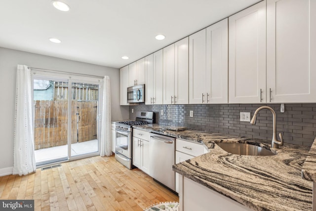 939 Sigel St, Philadelphia, PA 19148 - kitchen featuring appliances with stainless steel finishes, a sink, stone countertops, white cabinets, and recessed lighting