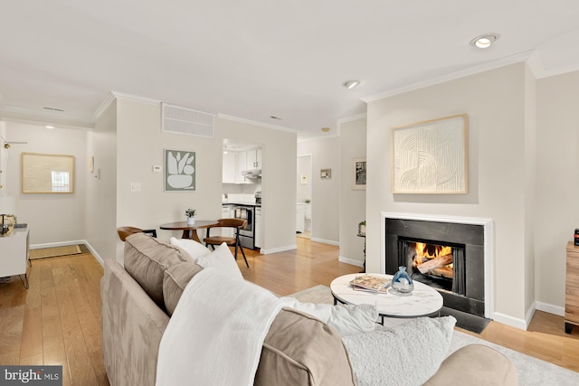 1801 Park Rd NW Unit 2, Washington, DC 20010 - living room with light wood finished floors, ornamental molding, a lit fireplace, recessed lighting, and baseboards