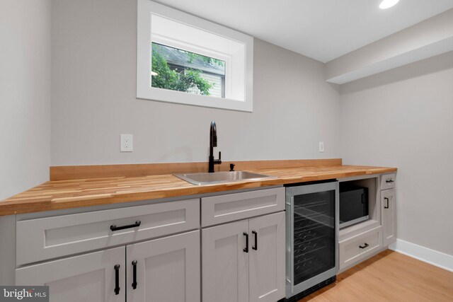 1427 Jackson St NE, Washington, DC 20017 - bar area featuring a sink, wine cooler, light wood finished floors, and baseboards
