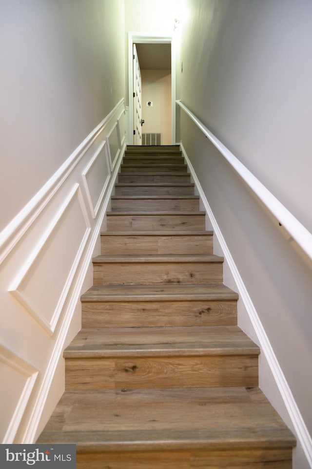 22 Thaxton Ct, Stafford, VA 22556 - stairway featuring wainscoting, a decorative wall, and wood finished floors