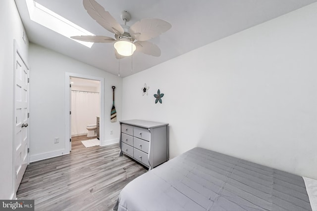 966 Walnut Ave, North Beach, MD 20714 - bedroom featuring light wood-type flooring, a skylight, vaulted ceiling, baseboards, and connected bathroom