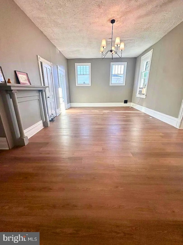 933 Mccormick Blvd, Clifton Forge, VA 24422 - unfurnished dining area with a textured ceiling, wood finished floors, a chandelier, and baseboards