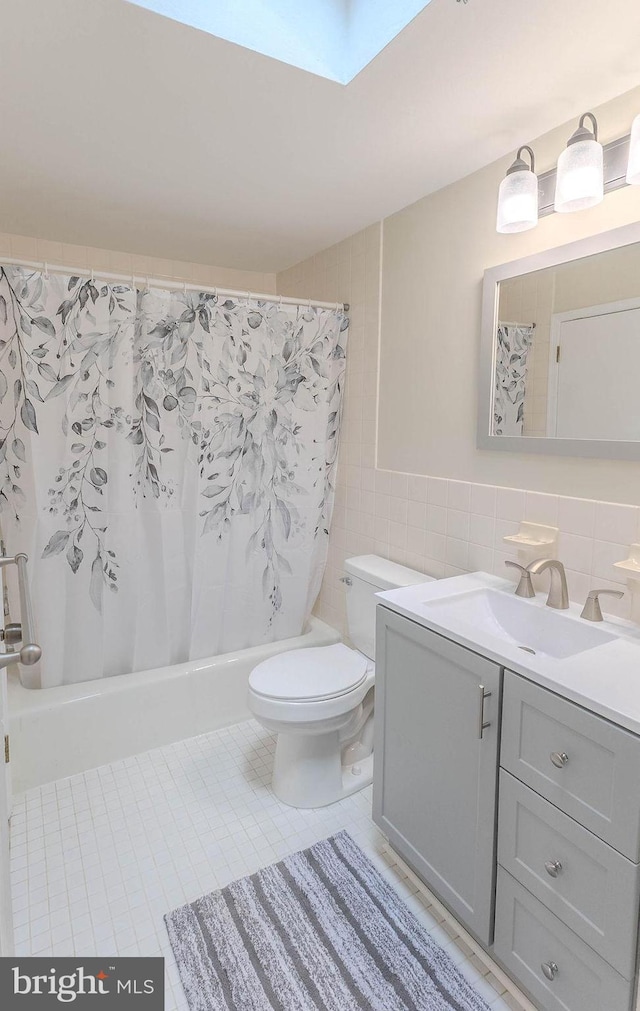 4128 Whiting Rd, Philadelphia, PA 19154 - bathroom with toilet, vanity, shower / bathtub combination with curtain, tile walls, and a skylight