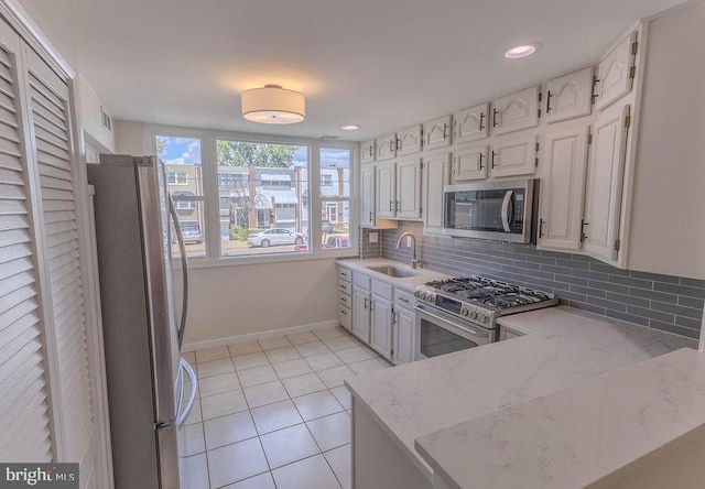 4128 Whiting Rd, Philadelphia, PA 19154 - kitchen featuring appliances with stainless steel finishes, a sink, light stone counters, backsplash, and light tile patterned floors