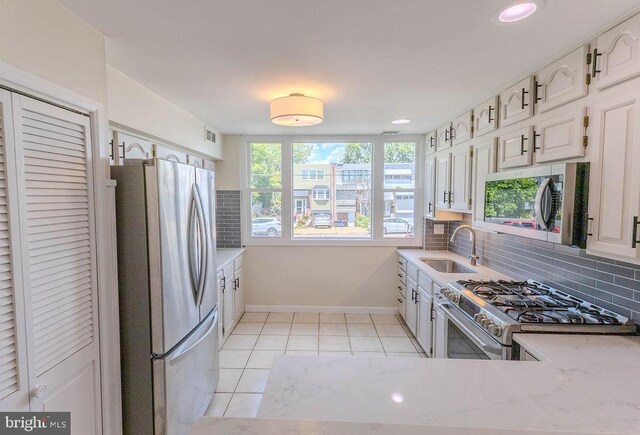 4128 Whiting Rd, Philadelphia, PA 19154 - kitchen featuring stainless steel appliances, a sink, baseboards, backsplash, and light countertops