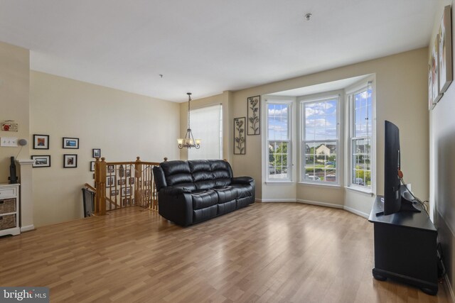 7140 Ladd Cir, Frederick, MD 21703 - living room featuring light wood-type flooring, a chandelier, and baseboards
