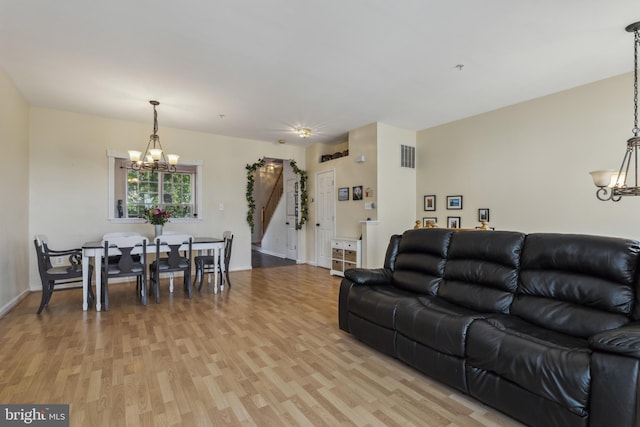 7140 Ladd Cir, Frederick, MD 21703 - living room with a chandelier, light wood-style flooring, stairway, and baseboards