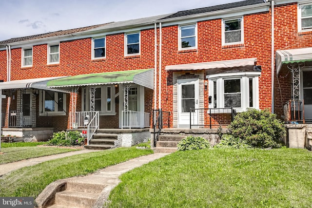 151 Bennett Rd, Essex, MD 21221 - view of property with brick siding, a front lawn, and covered porch