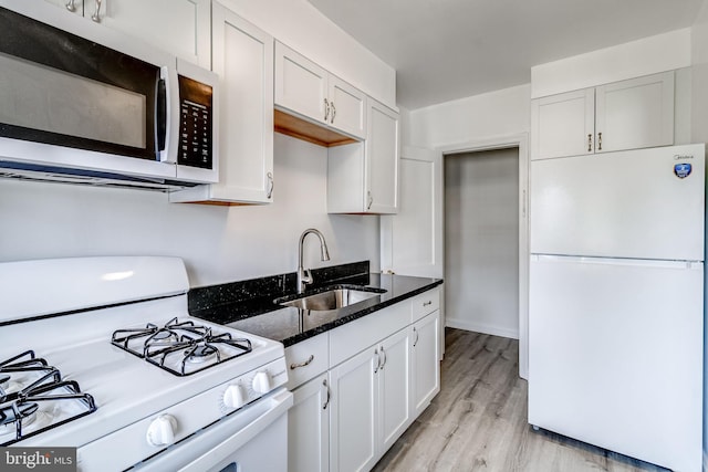 151 Bennett Rd, Essex, MD 21221 - kitchen with white appliances, a sink, dark stone counters, white cabinetry, and light wood finished floors