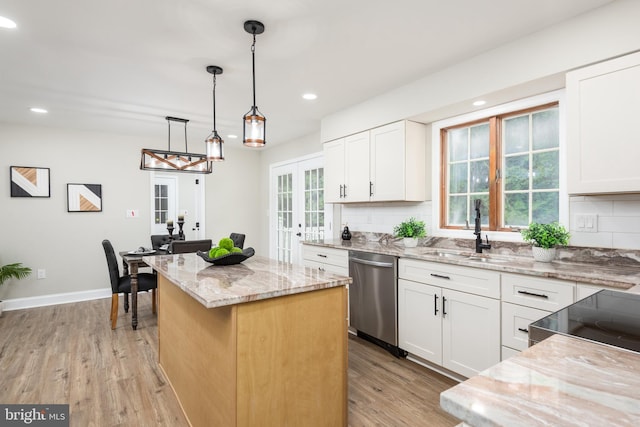 81 Rivers End Dr, Seaford, DE 19973 - kitchen featuring stainless steel dishwasher, a sink, a center island, french doors, and light stone counters
