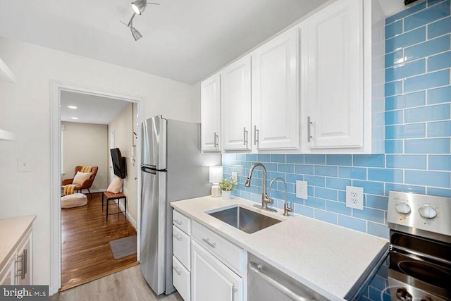 117 E Glebe Rd Unit C, Alexandria, VA 22305 - kitchen featuring a sink, light wood-type flooring, appliances with stainless steel finishes, white cabinets, and light countertops