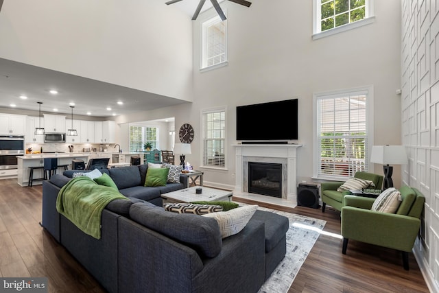 9909 Kildore Way, Fort Washington, MD 20744 - living area with a towering ceiling, ceiling fan, dark wood-type flooring, a fireplace, and recessed lighting