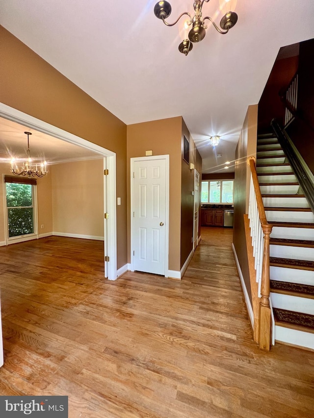 614 Wolfe Reserve Way, Harwood, MD 20776 - unfurnished living room with a chandelier, light wood-style floors, baseboards, and stairway