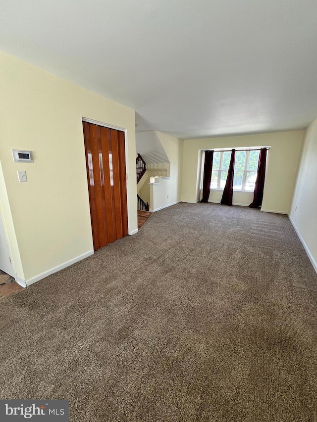 65 Auckland Dr, Newark, DE 19702 - unfurnished living room featuring carpet floors, baseboards, and stairway