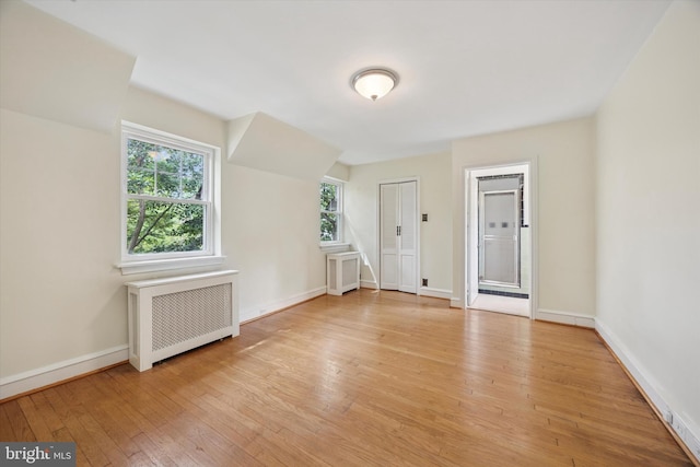 1100 Drexel Ave, Drexel Hill, PA 19026 - empty room with radiator heating unit, light wood-style floors, and baseboards