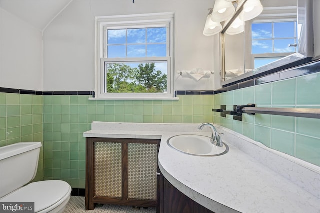 1100 Drexel Ave, Drexel Hill, PA 19026 - bathroom featuring toilet, vanity, tile walls, a wainscoted wall, and vaulted ceiling