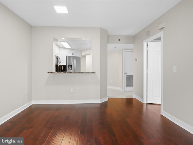 1045 N Utah St Unit 2-404, Arlington, VA 22201 - unfurnished living room featuring hardwood / wood-style flooring and baseboards