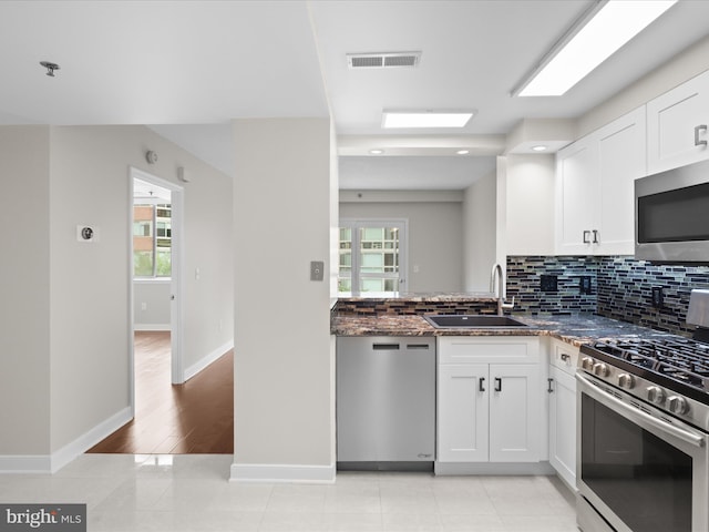 1045 N Utah St Unit 2-404, Arlington, VA 22201 - kitchen with stainless steel appliances, a sink, backsplash, white cabinets, and recessed lighting