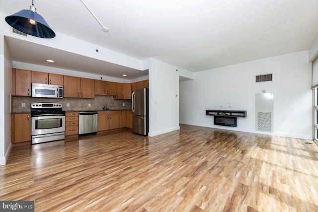 901 N Penn St Unit R305, Philadelphia, PA 19123 - kitchen featuring stainless steel appliances, open floor plan, dark countertops, and light wood-type flooring