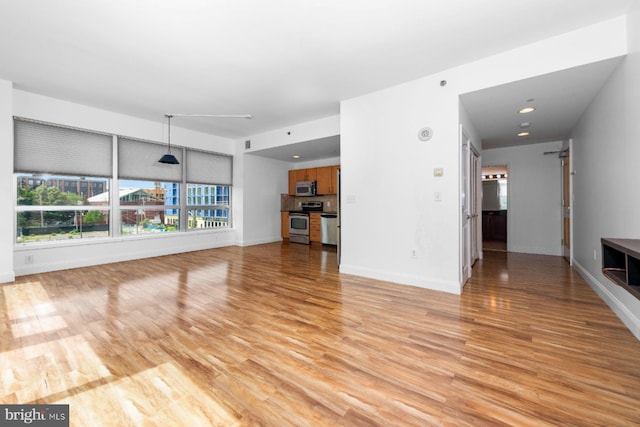 901 N Penn St Unit R305, Philadelphia, PA 19123 - unfurnished living room featuring light wood-type flooring, baseboards, and recessed lighting