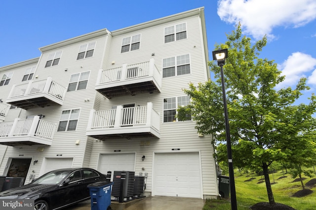 16894 Porters Inn Dr, Dumfries, VA 22026 - back of property featuring a garage, cooling unit, and driveway