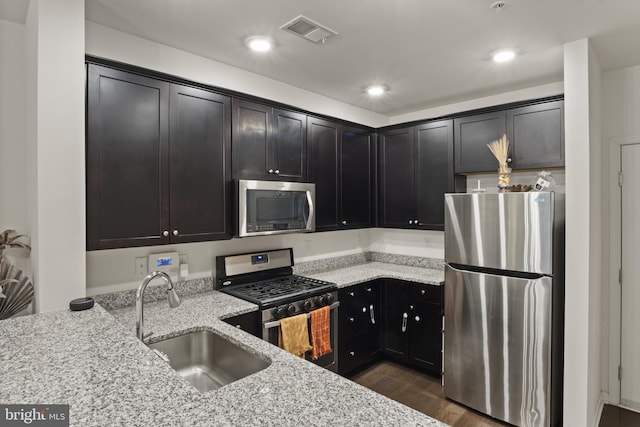 16894 Porters Inn Dr, Dumfries, VA 22026 - kitchen with stainless steel appliances, a sink, light stone counters, dark wood-style flooring, and recessed lighting