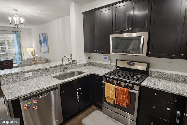 16894 Porters Inn Dr, Dumfries, VA 22026 - kitchen with stainless steel appliances, a sink, open floor plan, a chandelier, and a peninsula