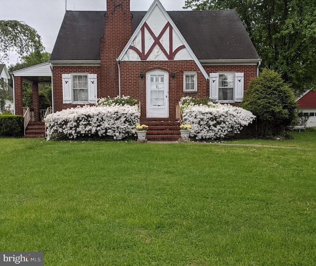 7457 Bradshaw Rd, Kingsville, MD 21087 - english style home featuring a chimney, a front yard, brick siding, entry steps, and a shingled roof