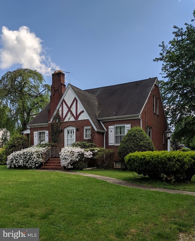 7457 Bradshaw Rd, Kingsville, MD 21087 - tudor house featuring brick siding, a chimney, a front lawn, and a shingled roof