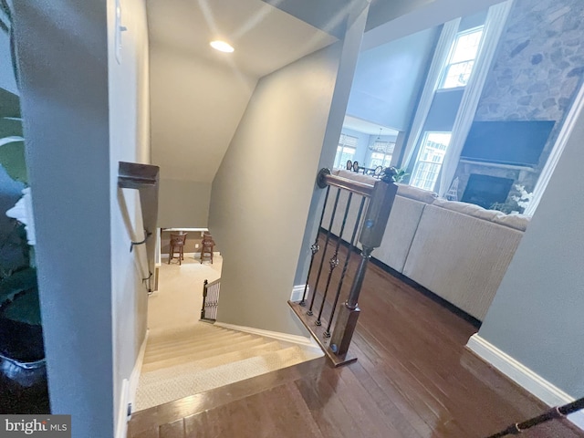 3348 Soaring Cir, Woodbridge, VA 22193 - staircase featuring hardwood / wood-style flooring, baseboards, a fireplace, and vaulted ceiling