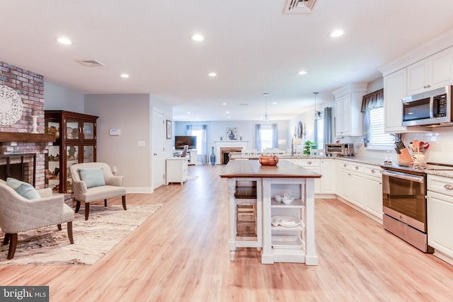 3 Canterbury Pl, Southampton, NJ 08088 - kitchen with stainless steel appliances, a fireplace, open floor plan, recessed lighting, and white cabinets