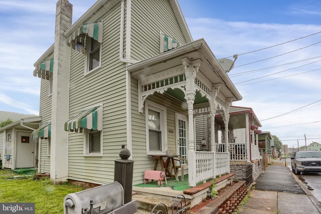 409 Julian St, Williamstown, PA 17098 - view of property exterior featuring a porch, a chimney, and asphalt driveway