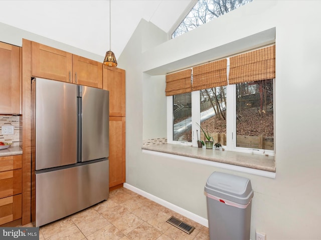 6518 Rimrock Rd, New Market, MD 21774 - kitchen with freestanding refrigerator, lofted ceiling, light countertops, light tile patterned floors, and decorative backsplash
