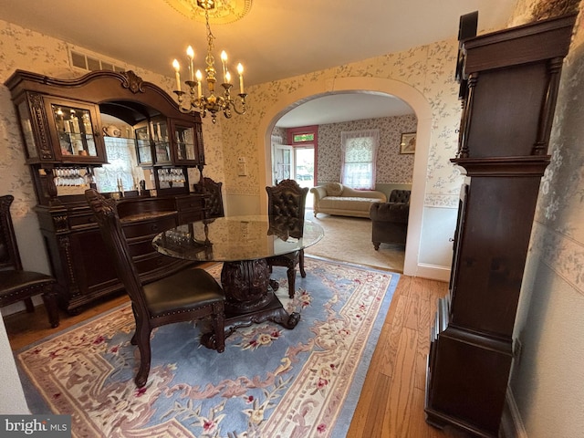 10 E Taunton Ave, Berlin, NJ 08009 - dining area with arched walkways, wallpapered walls, light wood finished floors, and a chandelier