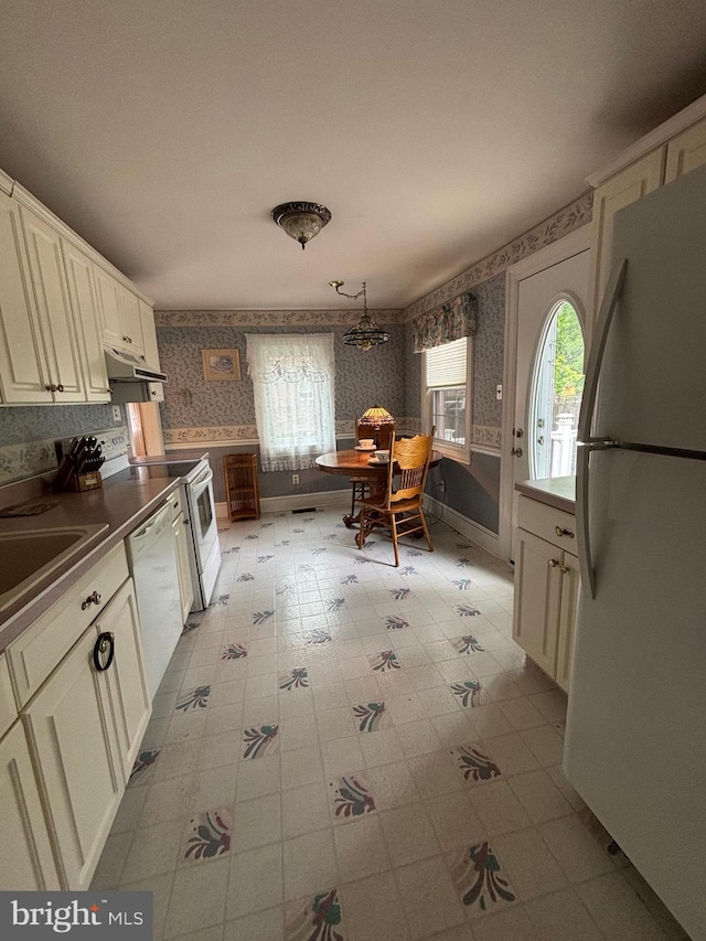 10 E Taunton Ave, Berlin, NJ 08009 - kitchen with wallpapered walls, white appliances, healthy amount of natural light, under cabinet range hood, and a sink