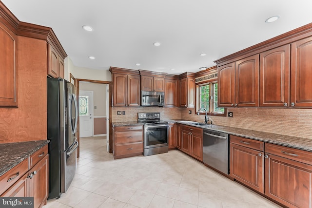 2 Raven Dr, Chadds Ford, PA 19317 - kitchen with stainless steel appliances, a sink, tasteful backsplash, dark stone countertops, and light tile patterned floors