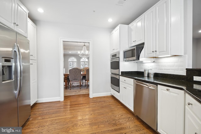 9630 Beman Woods Way, Potomac, MD 20854 - kitchen featuring appliances with stainless steel finishes, dark countertops, white cabinetry, backsplash, and light wood-style flooring