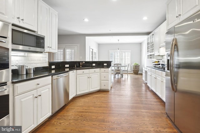 9630 Beman Woods Way, Potomac, MD 20854 - kitchen featuring appliances with stainless steel finishes, a peninsula, white cabinets, tasteful backsplash, and recessed lighting