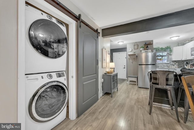 35 La Cascata, Clementon, NJ 08021 - laundry room featuring stacked washer / drying machine, a barn door, and light wood-style flooring
