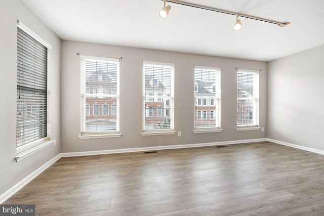20866 Rockingham Ter, Sterling, VA 20165 - spare room featuring healthy amount of natural light, track lighting, wood finished floors, and baseboards