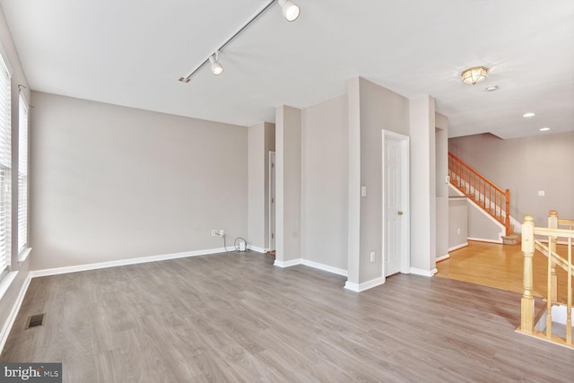 20866 Rockingham Ter, Sterling, VA 20165 - spare room with wood finished floors, stairway, track lighting, and baseboards
