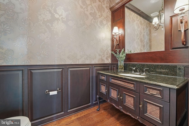 2555 Vale Ridge Ct, Oakton, VA 22124 - bathroom with wallpapered walls, vanity, wood finished floors, a wainscoted wall, and a decorative wall