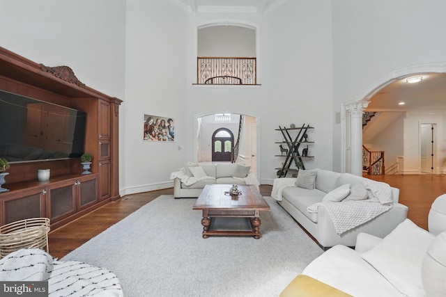 2555 Vale Ridge Ct, Oakton, VA 22124 - living room with arched walkways, wood finished floors, a towering ceiling, ornate columns, and stairway