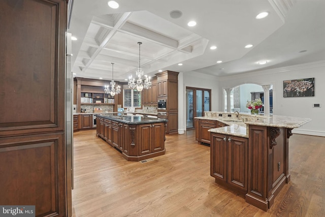 2555 Vale Ridge Ct, Oakton, VA 22124 - kitchen featuring a large island with sink, a sink, decorative columns, a chandelier, and crown molding