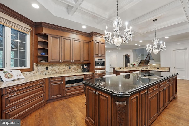 2555 Vale Ridge Ct, Oakton, VA 22124 - kitchen with a large island, light wood finished floors, a chandelier, coffered ceiling, and decorative backsplash
