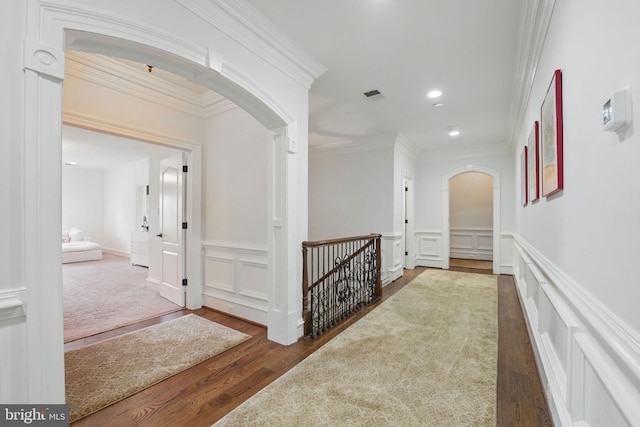 2555 Vale Ridge Ct, Oakton, VA 22124 - hallway featuring arched walkways, a decorative wall, wood finished floors, an upstairs landing, and ornamental molding