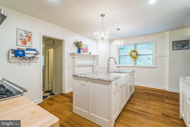 355 Arden, Gulph Mills, PA 19428 - kitchen with a sink, a chandelier, white cabinetry, wood finished floors, and light stone counters