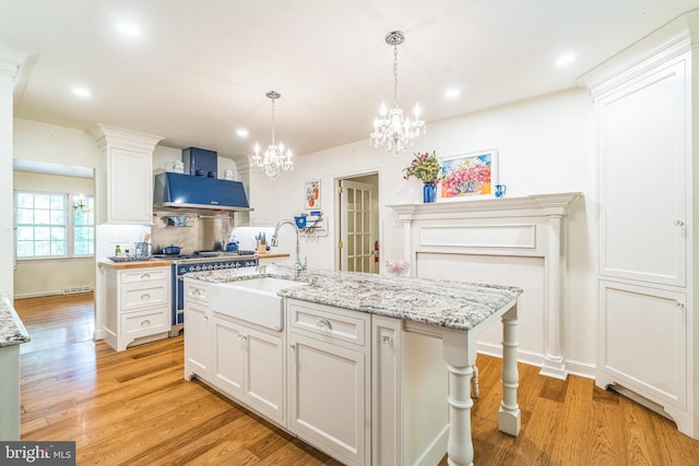355 Arden, Gulph Mills, PA 19428 - kitchen with a sink, stainless steel stove, a chandelier, white cabinets, and light wood-style floors