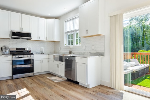528 N Third St, Martinsburg, WV 25404 - kitchen with stainless steel appliances, light wood-style floors, tasteful backsplash, white cabinets, and recessed lighting